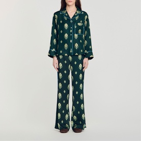 Model wearing Sandro green satin pyjama set with gold geometric print, long-sleeve shirt and wide-leg trousers
