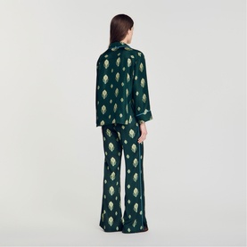 Model wearing Sandro green satin pyjama set with gold artichoke print, long-sleeve shirt and wide-leg trousers, back view