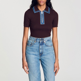 Model wearing dark brown knit polo top with blue contrast trim and zip neck, styled with light wash straight-leg jeans