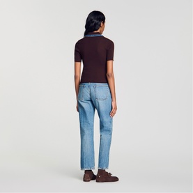 Model wearing dark burgundy ribbed short-sleeve polo top, styled with light blue straight-leg jeans, seen from behind