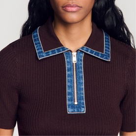 Model wearing dark brown ribbed knit polo top with denim contrast collar and gold half-zip detail, close-up view