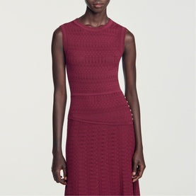 Model wearing Sandro red sleeveless knit midi dress with textured pattern and side button detail