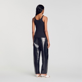 Model wearing Sandro Lace Trim Ribbed Tank Top in black with V-neckline, styled with metallic wide-leg trousers and white mule sandals.