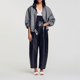 Model wearing Sandro Lace Trim Ribbed Tank Top in black, styled with grey oversized jacket and black leather trousers.