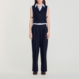 Model wearing Sandro navy blue sleeveless waistcoat and wide-leg trousers, styled with a light blue collared shirt underneath.