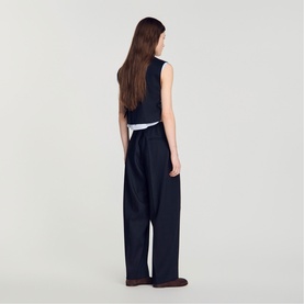 Model wearing Sandro Womens French Dress in navy blue, wide-leg trousers, styled with a sleeveless white top, back view.
