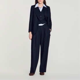 Model wearing Sandro navy blue wide-leg trousers with matching blazer and vest, styled with a white collared shirt