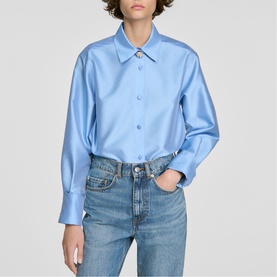 Model wearing Sandro sky blue satin shirt with point collar and button front, styled with light wash jeans