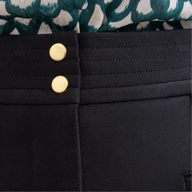 Phase Eight black trousers with gold button detail and pintuck waistband, close-up view