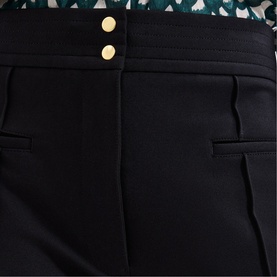 Phase Eight black tailored trousers with gold double-button waistband detail and side pockets, styled with a printed blouse