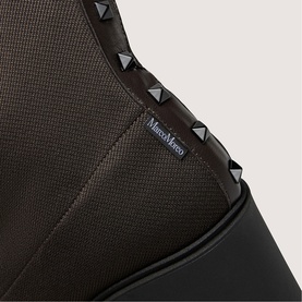 Marco Moreo brown shoe close-up showing textured upper, black sole, and gunmetal pyramid stud trim detail along the collar.