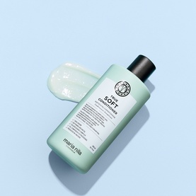 Maria Nila True Soft Conditioner in mint-green bottle shown flat lay on light blue background with product texture swatch