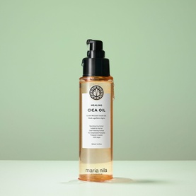 Maria Nila Healing Cica Oil hair oil in amber glass pump bottle with black pump dispenser against sage green background