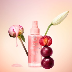 Maria Nila Floral Hair Mist in pink spray bottle styled with peony, tulip and fresh cherries on a soft pink background