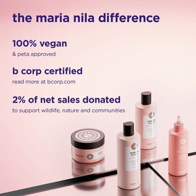 Maria Nila haircare range including treatment jars and bottles in blush pink packaging, displayed on a mirrored surface