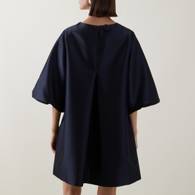 Model wearing Roisin Linnane Olivia Mini Dress in navy, rear view, showing wide sleeves, relaxed A-line silhouette and back zip detail.