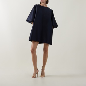 Model wearing Roisin Linnane Olivia Mini Dress in navy, featuring voluminous sleeves and A-line silhouette, styled with strappy heeled sandals.