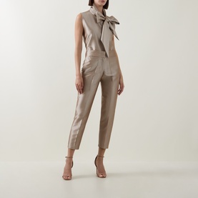 Model wearing Roisin Linnane Mya Bow-Detail Top in gold, styled with matching tapered trousers and nude heeled sandals.