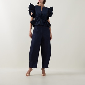 Model wearing Roisin Linnane Navy Trousers in cotton, styled with matching navy ruffle top and gold heeled sandals.