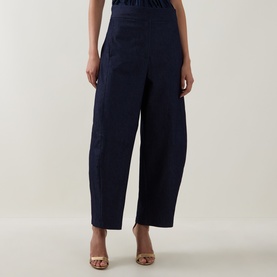 Model wearing Roisin Linnane navy cotton wide-leg trousers with elasticated waist, styled with tan heeled sandals.