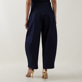 Model wearing Roisin Linnane navy wide-leg cotton trousers, rear view, styled with gold strappy heels.