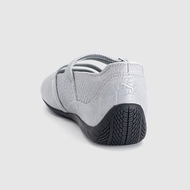 Puma trainer in white croc texture, cross-strap upper detail, black rubber sole, rear three-quarter view
