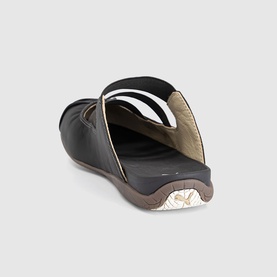 Puma women's slip-on shoe in Espresso Bean, black leather upper with gold trim detail and brown rubber sole, rear view.