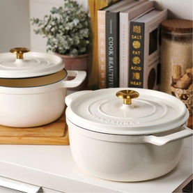 Tramontina latte casserole dishes with gold knob lids, styled on a kitchen shelf with books and storage jars