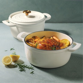 Tramontina latte casserole dishes styled with roast chicken, potatoes and lemon, one lidded with gold knob, one open showing contents