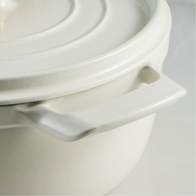 Tramontina latte casserole dish with lid, close-up showing handle and smooth ceramic finish in warm white tone