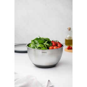 Tramontina stainless steel mixing bowl with non-slip base, filled with fresh basil and cherry tomatoes, styled on marble surface