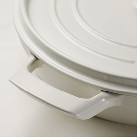 Tramontina latte pan with fitted lid, showing curved side handle detail in smooth ceramic-style finish