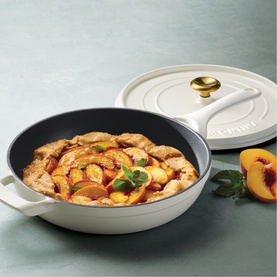 Tramontina Saute Pan in latte with gold-toned knob lid, filled with saut&eacute;ed peaches and chicken, styled with fresh peaches alongside