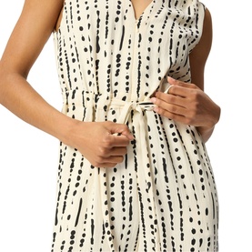 Model wearing Whistles cream sleeveless dress with black dot and dash print, button placket, and self-tie waist belt, close-up detail view.