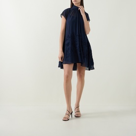 Model wearing Jonathan Simkhai Aviel Floral Appliqu&eacute; Mini Dress in Midnight, draped chiffon silhouette with high neckline, styled with black strappy