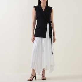 Model wearing Jonathan Simkhai Black Multi Dress with wrap-style sleeveless black bodice, tie waist, and white pleated asymmetric skirt, styled with