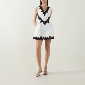 Model wearing Jonathan Simkhai Ivory Multi dress with black lace V-neckline and hem trim, styled with black strappy heels