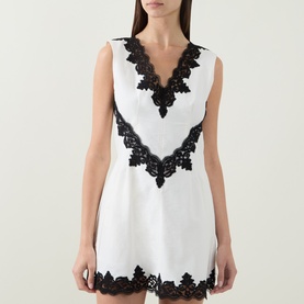 Model wearing Jonathan Simkhai Ivory Multi dress with V-neckline and black lace trim detailing at neckline, waist and hem