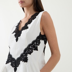 Model wearing Jonathan Simkhai Ivory Multi dress with black lace V-neckline trim and floral lace panel detail, sleeveless style