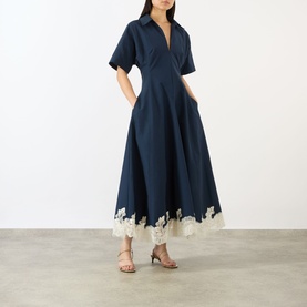 Model wearing Jonathan Simkhai Nerris Contrast Lace Dress in Midnight Multi; midi length, pointed collar, flared skirt with cream lace hem trim.