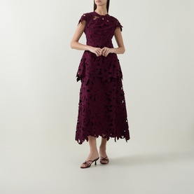 Model wearing Jonathan Simkhai fig lace midi dress with floral cutwork detail, styled with strappy heeled sandals.