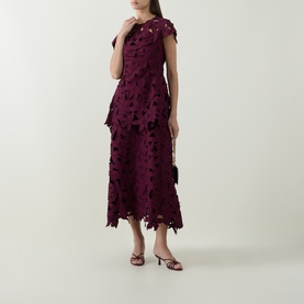 Model wearing Jonathan Simkhai fig floral cutwork midi dress with cap sleeves, styled with strappy heeled sandals and small black clutch bag.