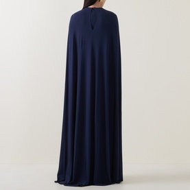 Model wearing Jonathan Simkhai Gown in Midnight, rear view showing dramatic floor-length cape overlay with keyhole neckline detail.