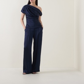 Model wearing Jonathan Simkhai Midnight one-shoulder draped acetate top, styled with matching wide-leg trousers and black heeled sandals.