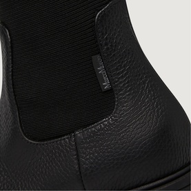 Marco Moreo black pebbled leather Chelsea boot, close-up showing elastic side panel with branded tab detail.