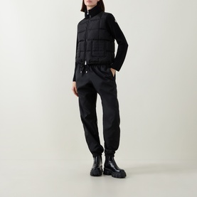 Model wearing Moncler black cardigan with quilted front panel, styled with black joggers and chunky boots