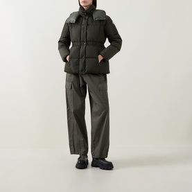 Model wearing Moncler green quilted puffer jacket with hood, styled with matching cargo trousers and black chunky-sole boots.