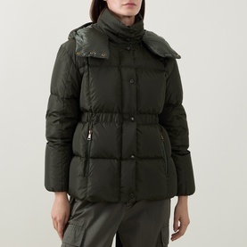 Model wearing Moncler green quilted down puffer jacket with funnel neck, belted waist, and snap-front fastening