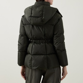 Model wearing Moncler green quilted puffer jacket, rear view, with detachable hood, belted waist, and matching green trousers.