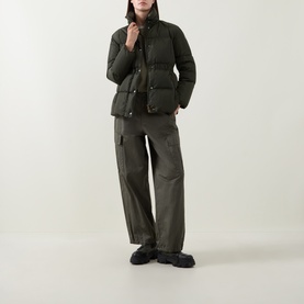 Model wearing Moncler green quilted down jacket with gold-tone buttons, styled with khaki cargo trousers and black chunky loafers